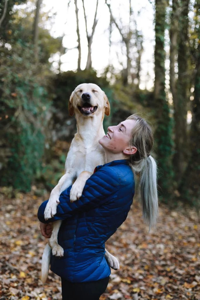 Junge Frau mit Ihrem Hund im Wald - Versicherungen